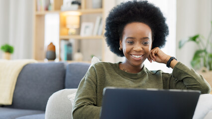 Laughing afro woman using laptop to watch funny, comedy movies or videos. Smiling, happy woman with...