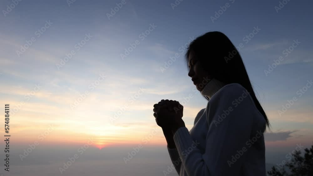 Wall mural Slow motion, Silhouette of woman praying over beautiful sunrise background, beautiful landscape, pay homage, spirituality and religion, Christianity concept. - Wall murals