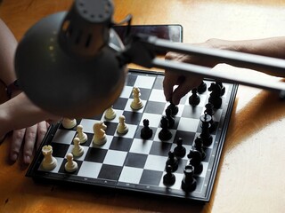 Chess duel between a teenager and a grandmother.Board educational games. The hands of chess players...