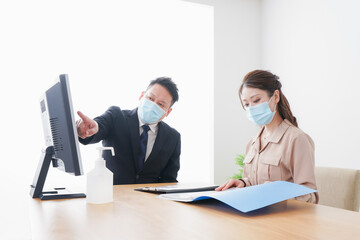 Obraz premium 感染症対策をしてオフィスで働くビジネスパーソン