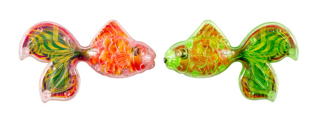 Red and green toy fish on a white background. Two toy plastic fish.