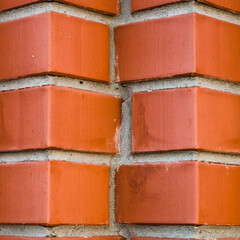 Individual design of red brick wall from diagonally angular bricks close up. Geometric background...