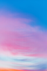 Beautiful backdrop of sunset sky with pink orange light clouds in blue sky. Colorful smooth dawn sky gradient. Nature background of sunrise. Amazing morning heaven. Slightly cloudy evening atmosphere.