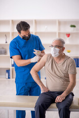 Fototapeta premium Old male patient visiting young male doctor in vaccination conce