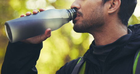 Man, hiking or drinking water in nature forest, woods or fitness environment for break,...