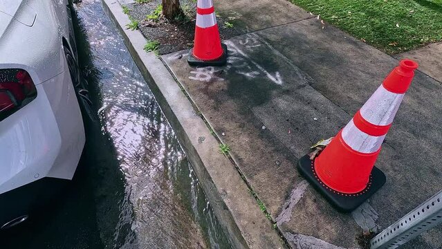 Flooding water stream on the street near the damaged fire hydrant and traffic cones in Los Angeles, California, 4K