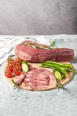 Smoked beef tongue. Sliced Smoked Veal Tongue on Wooden Cutting Board. Delicious smoked meat. Local name fume dana dil