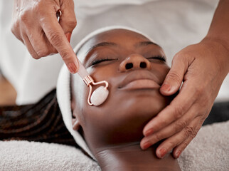 Facial roller, spa and black woman relax for massage, wellness and skincare cosmetics at salon....