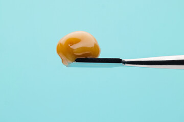 Live Rosin on a dab tool with a light blue background