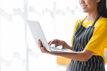 Young pretty asian start up business woman in apron working with online parcel box warehouse selling online product with social media influencer people with subscriber and followers