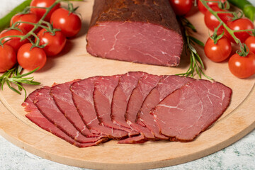 Dry meat. Slices of dried and smoked dry meat on a wooden board. Beef jerky pieces