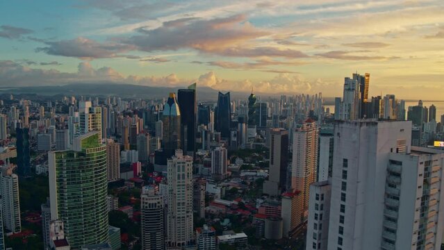 Drone shot of Panama City at sunrise, skyline and many buildings in front while traveling
