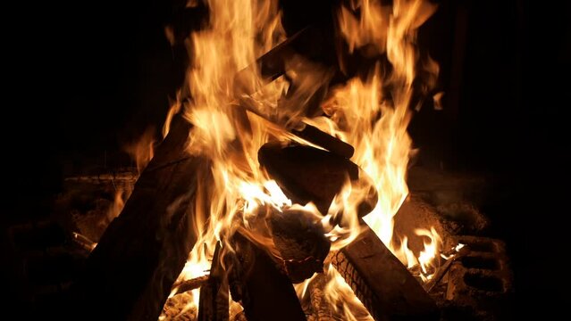 Wood fire burning intensely with flames dancing wildly, filmed as medium close up shot