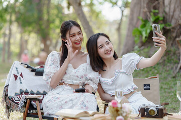 Two pretty asian friends woman picnic at park outdoor in relax time holiday, holiday recreation...