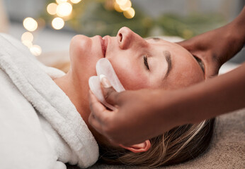Beauty, gua sha and woman getting a facial massage for wellness, health and self care at a spa. Skincare, cosmetic and calm young female doing a luxury face treatment with rose quartz at a zen salon.