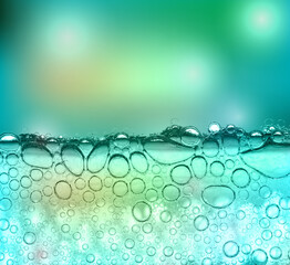 Bubbles in a clear green liquid with a blurred blue-green background and bokeh