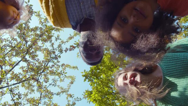 Bottom View Of Happy Diverse Family Looking Down At Camera. Realtime