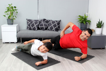 Overweight Latino dad and son exercise at home to lose weight and be healthy to avoid diseases such...