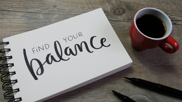 FIND YOUR BALANCE lettering in notebook with cup of coffee and pens