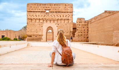 Woman tourist visiting old ruin palace ( Palais El Badi) in Marrakech,  Morocco - obrazy, fototapety, plakaty