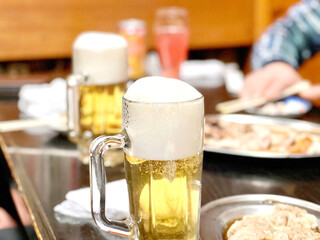 泡があふれそうなビールを置いた宴会の席 © smile