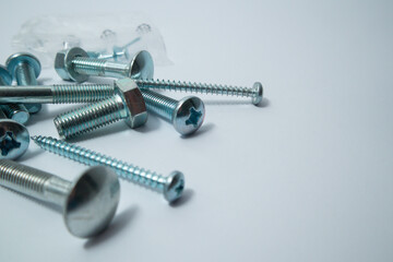 Set of bolts on a white background. Construction abstraction. Industrial background. Screws and bolts macro photo, screw background, steel screw, bolt macro.