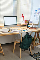 Vertical image of desk with computer monitor on it for online study in the bedroom of teenager