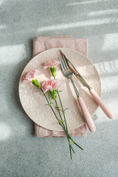 Table setting with pink carnation flowers
