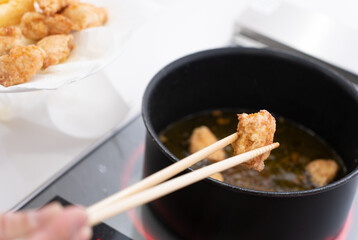 唐揚げを自宅のIHキッチンで作る主婦