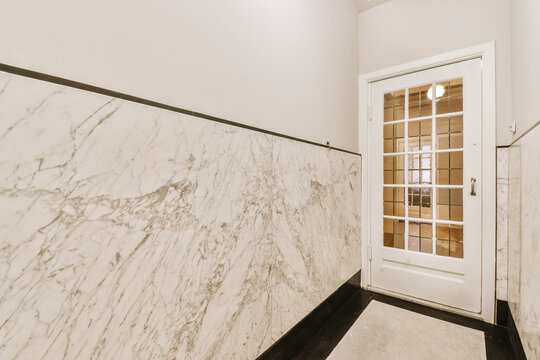 Narrow room with door and marble walls