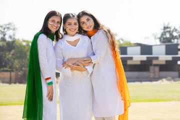 Independence day or republic day concept. Young happy indian women wearing white kurta with tricolor duppata dress standing at park,