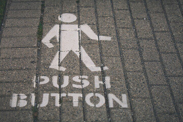 A painted man with Push Button underneath instructs pedestrians of how to prompt a crosswalk.