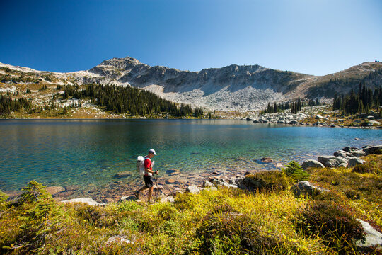 A ultralight backpacker hikes along the shore of Valentine Lake near Pemberton, BC, Canada.