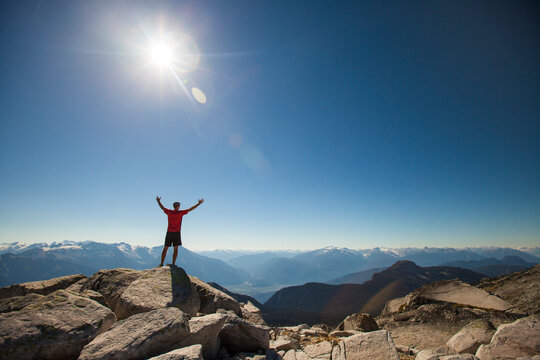 A hiker celebrates after reaching the summit of Cassiope Peak near Pemberton, British Columbia, Canada.