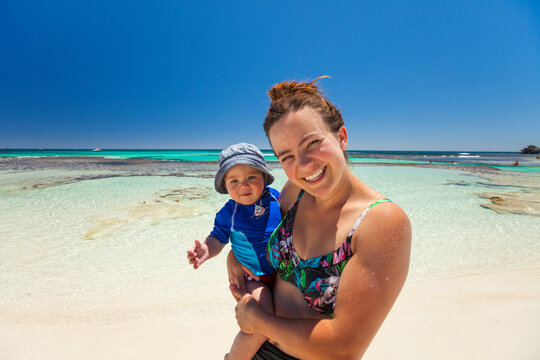 Mother holding baby on coastal beach, Yallingup, Western Australia, Australia
