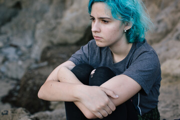Teen girl sitting with her arms crossed around her knees