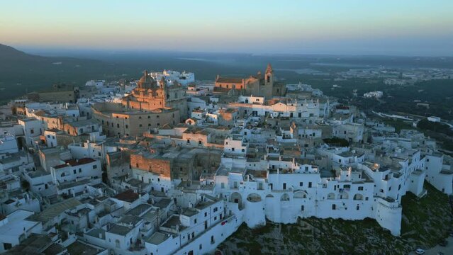Aerial drone panning shot of the historical italian town Ostuni during sunset.
