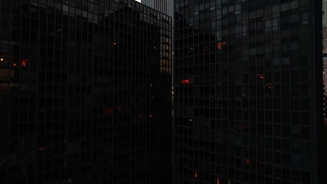 revealing chicago behind two tall black buildings. Rising Aerial 4k Illinois USA