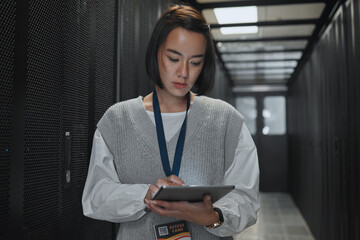 Plakat Tablet, server room and networking with a programmer asian woman at work on a computer mainframe. Software, database and information technology with a female coder working alone on a cyber network