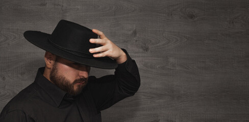 huaso claiming black hat on panoramic wooden background