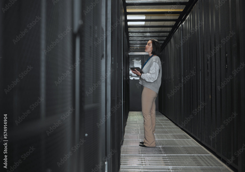 Poster Tablet, server room and storage with a programmer asian woman at work on a computer mainframe. Software, database and information technology with a female coder working alone on a cyber network
