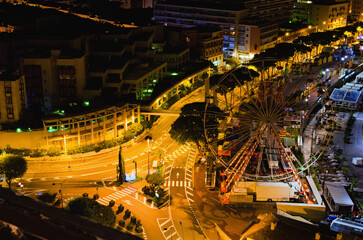 Aerial nightlight landscape of streets in Monaco. Illuminated residential buildings in the...