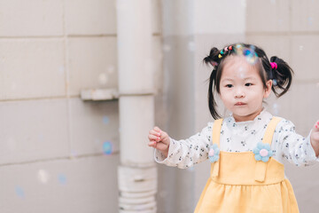 A cute happy little girl asian playing bubble outdoor.