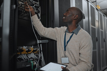 Engineer, server room and black man with cable and tablet for database maintenance or software...