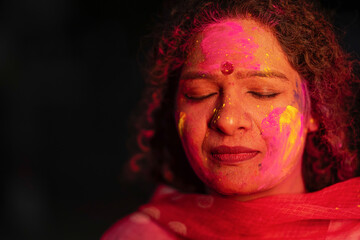 Close view of Indian woman face covered with powder paint during Holi festival