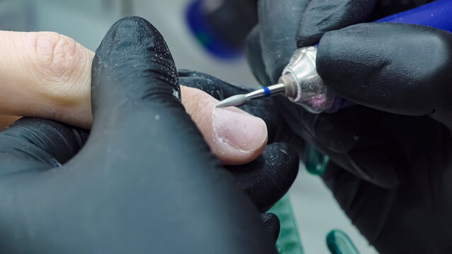 Electric nail file drill in action. Manicure