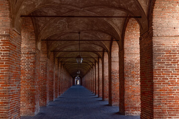 Red brick columns and arches in Galleria degli Antichi in Sabbioneta town. Lombardy, Italy