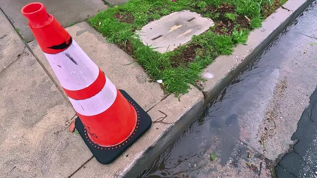Flooding water stream on the street near the damaged fire hydrant and traffic cones in Los Angeles, California, 4K