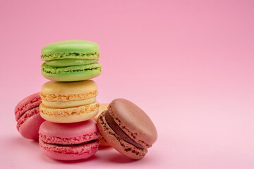 Obraz na płótnie Canvas Pyramid of colorful french macarons isolated on pink background.