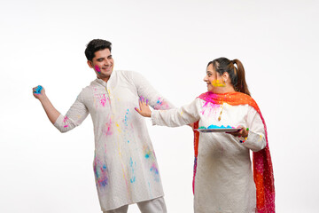 Obraz premium Indian man trowing color on woman celebrate holi festival.